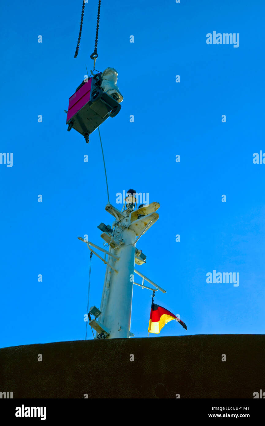 loading of a ship, hovering load, mast and german flag  , Germany Stock Photo