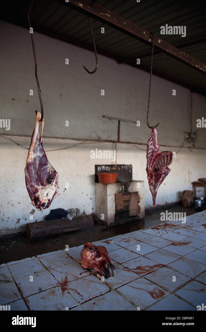Fresh goat meat is being offered on public market in bad hiegene conditions, dried blood on tiled surface, Rwanda, Nyamirambo, Kigali Stock Photo