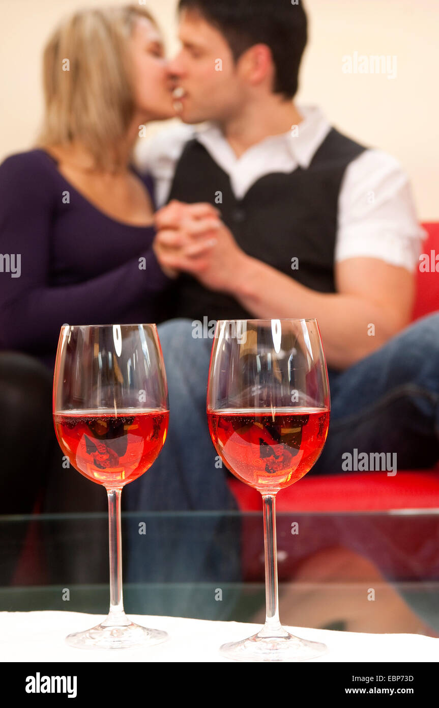 two wine glasses, lovers kissing in background, Germany Stock Photo