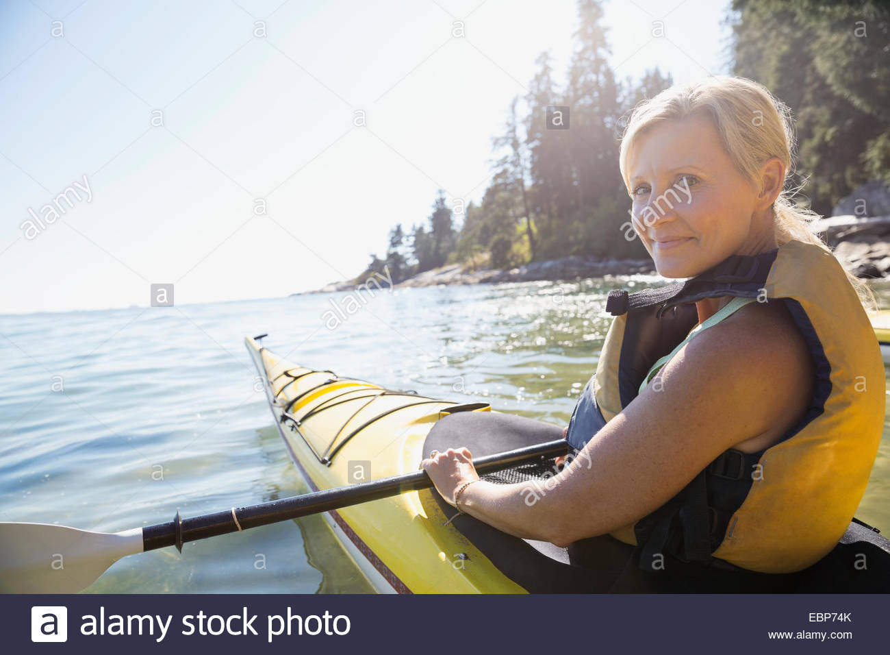 Portrait of woman kayaking on sunny ocean Stock Photo