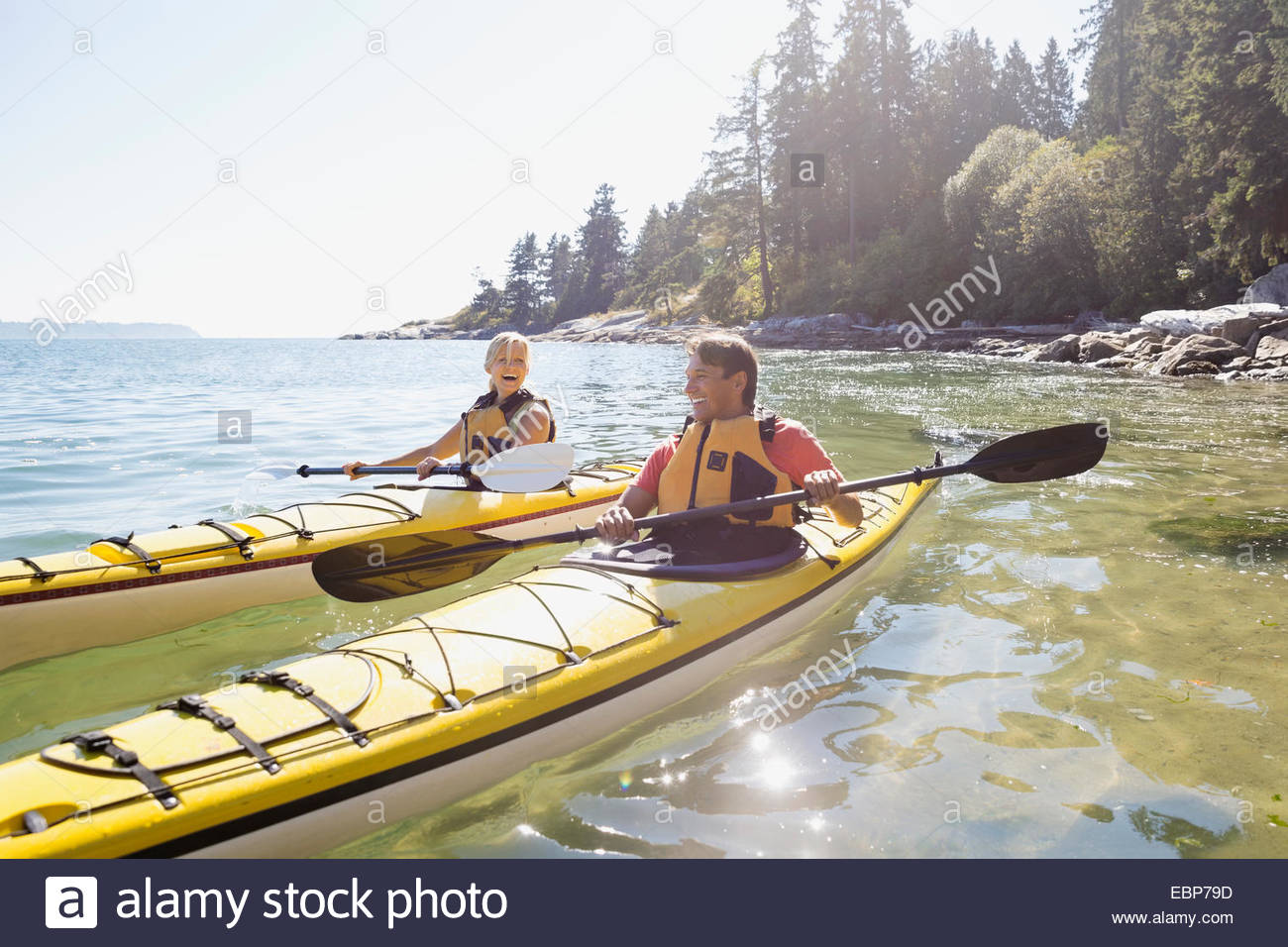 Couple kayaking on sunny ocean Stock Photo