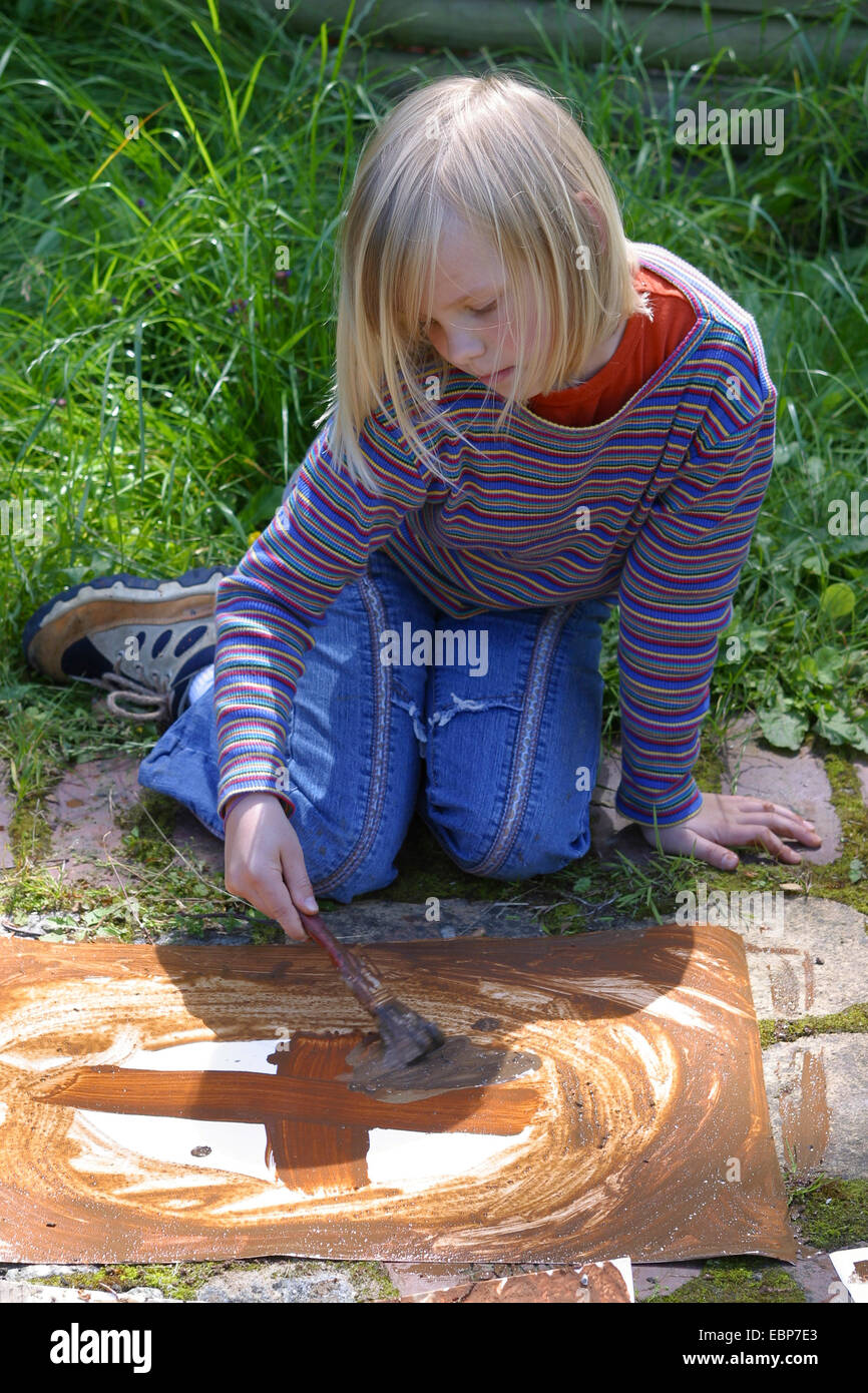 a girl painting with earth colour, Germany Stock Photo