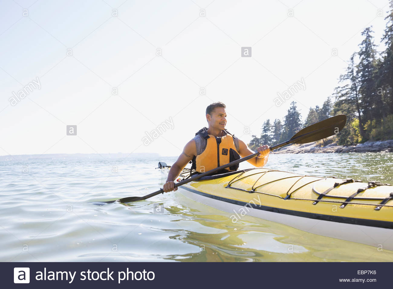 Man kayaking on sunny ocean Stock Photo