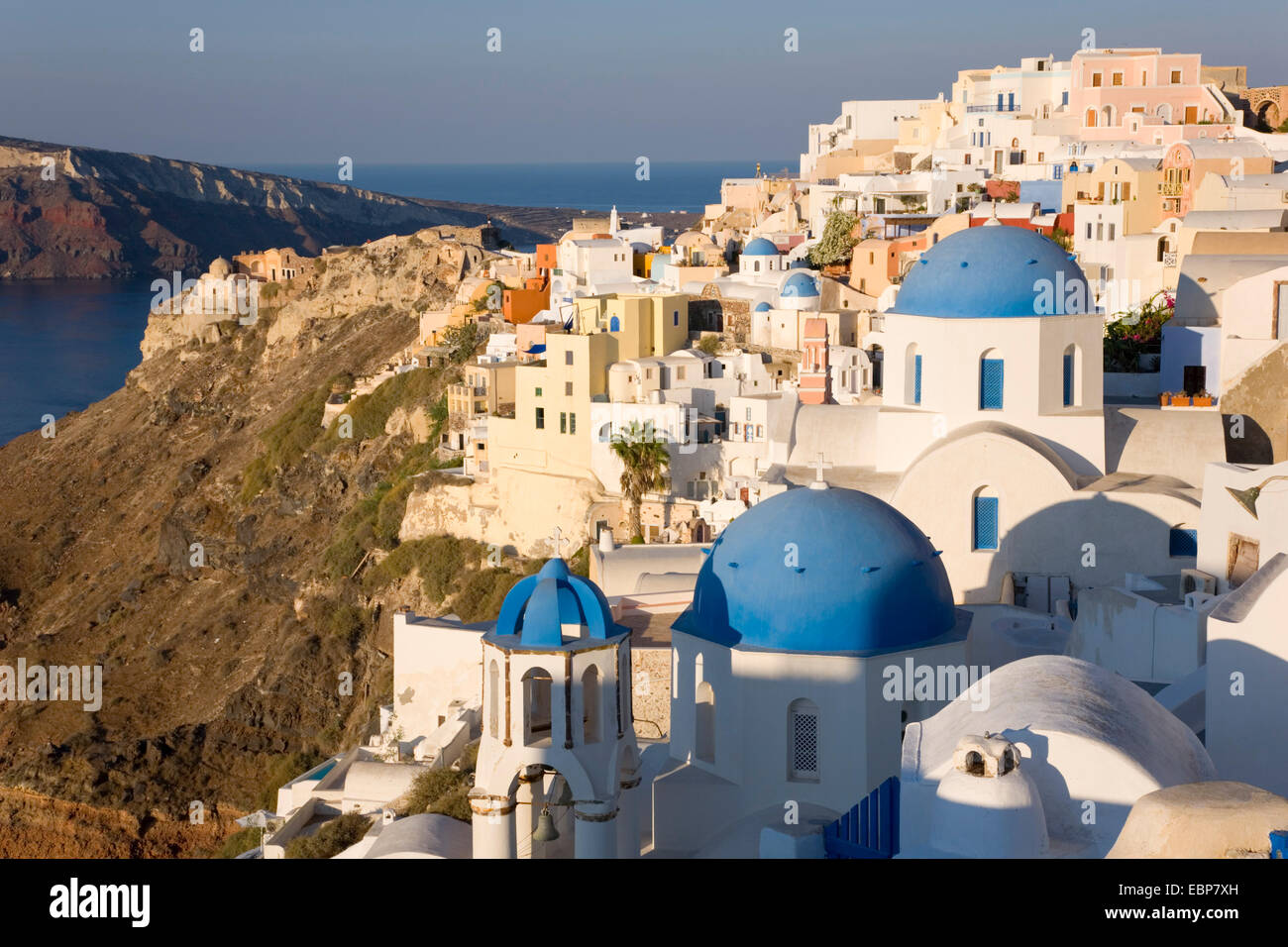 Ia, Santorini, South Aegean, Greece. The village at sunrise, typical blue-domed churches prominent. Stock Photo
