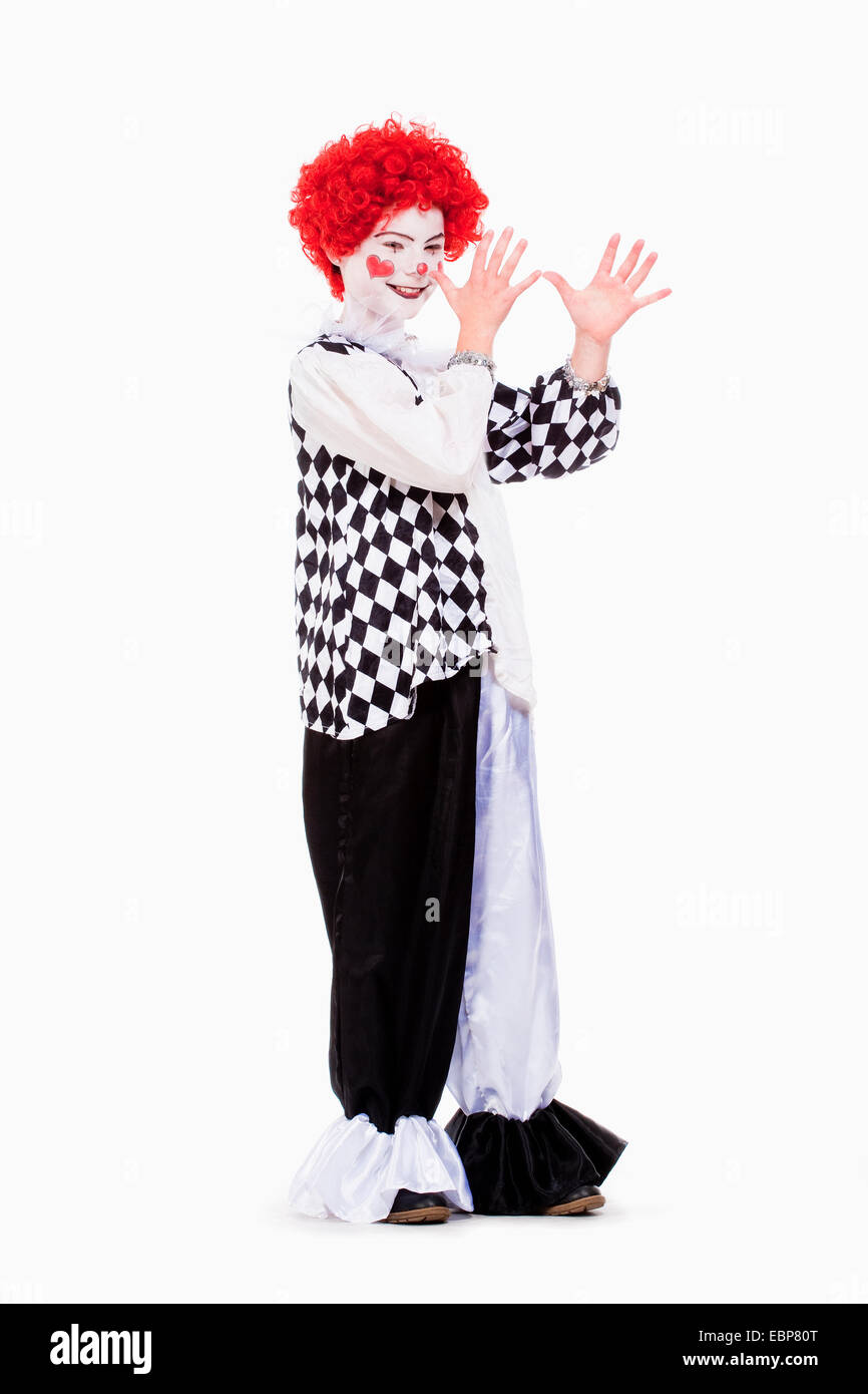 Little Girl in Red Wig, Makeup and Outfit Posing as a Clown. Stock Photo
