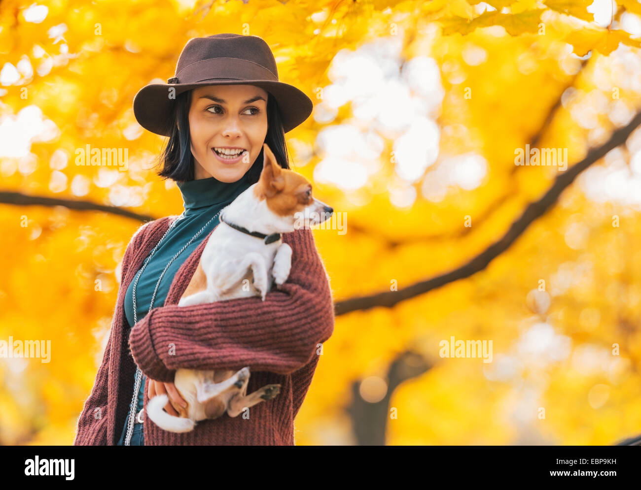 Portrait of happy young woman with dog outdoors in autumn looking on copy space Stock Photo