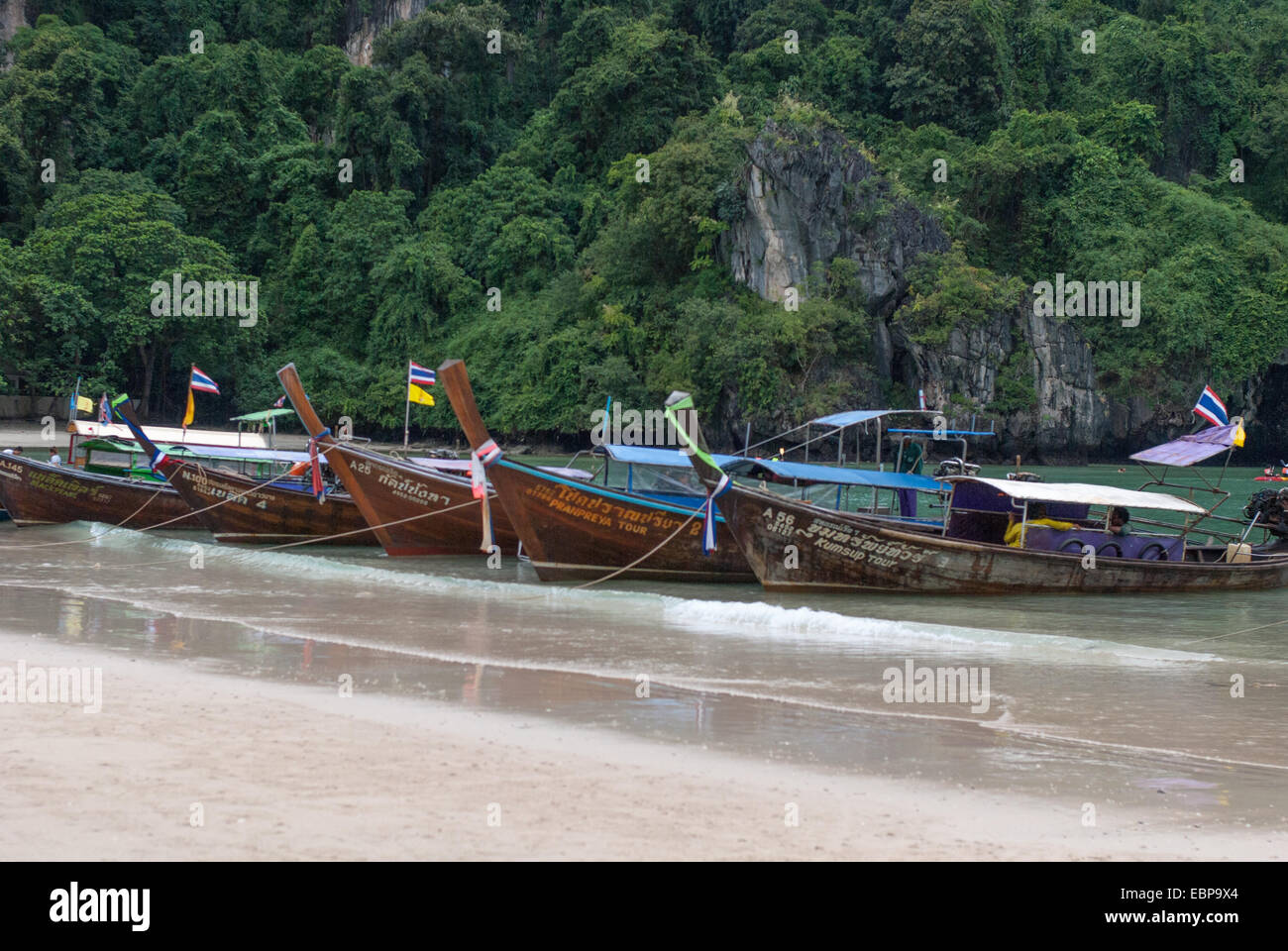 Longtail boats lined Railay Beach in Thailand Stock Photo