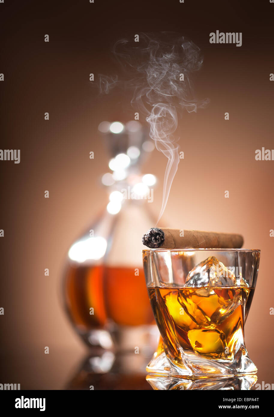 Cigar on glass with whiskey on brown background Stock Photo