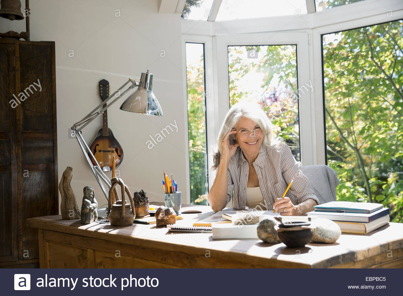 Portrait of senior woman writing in home office Stock Photo