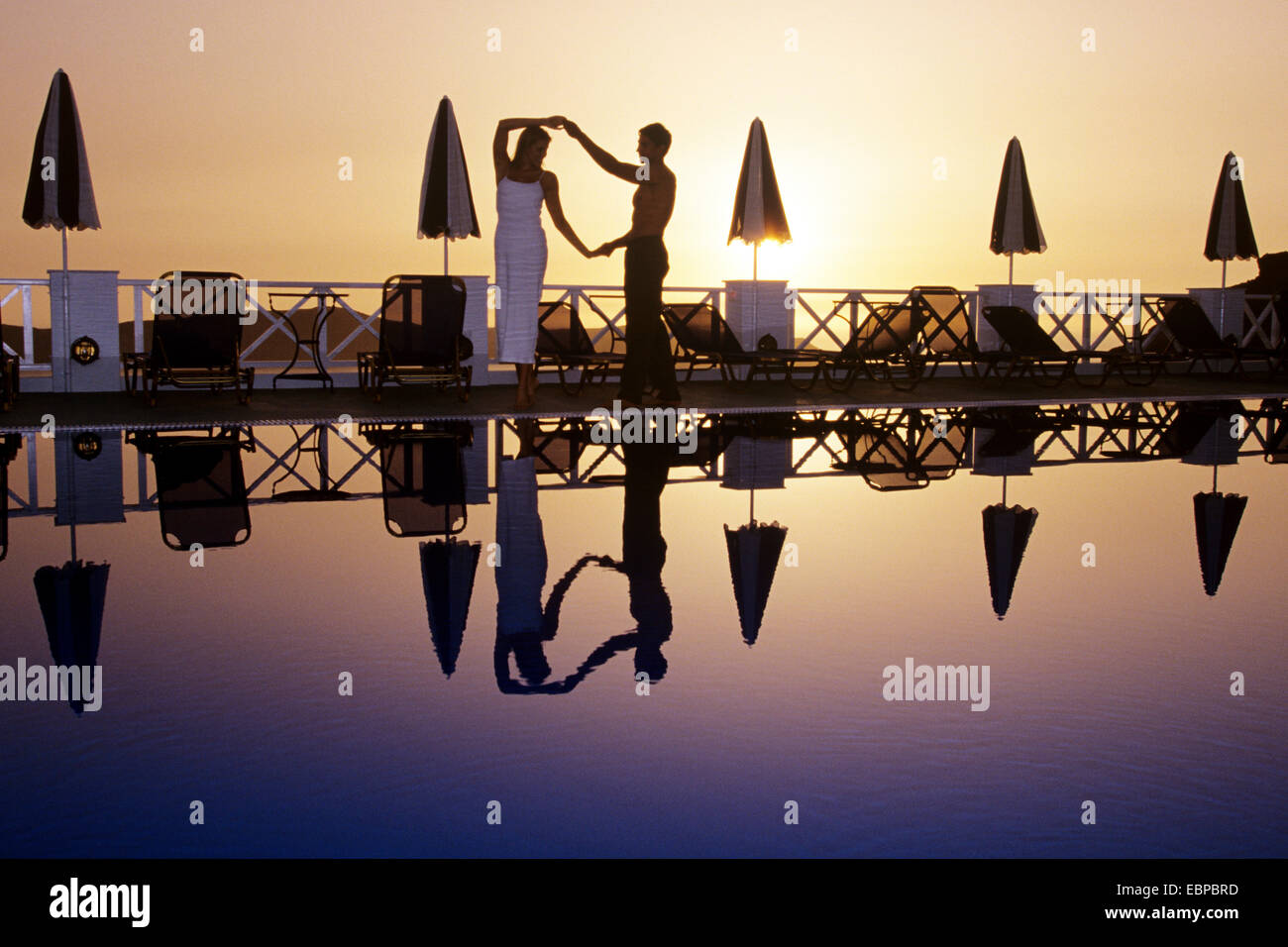 couple by pool at sunset, Fira, Santorini, Greece Stock Photo