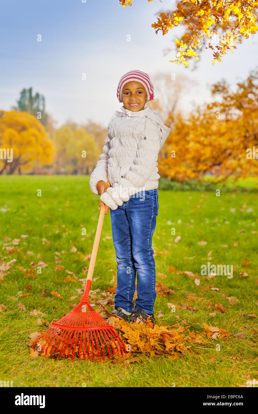 African girl working with red rake in park alone Stock Photo - Alamy