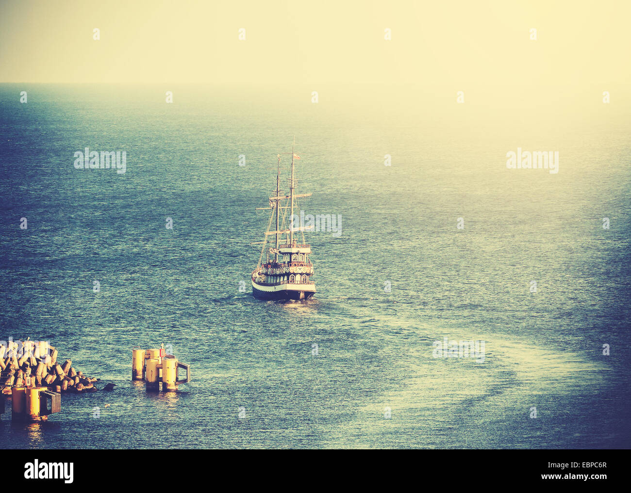 Vintage picture of old sailing ship leaving port. Stock Photo