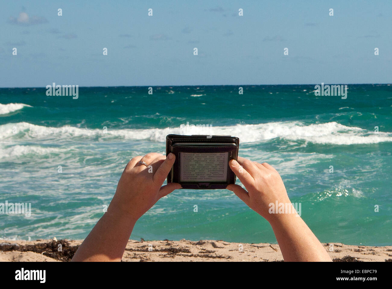 Reading an Amazon Kindle in the beach Stock Photo Alamy