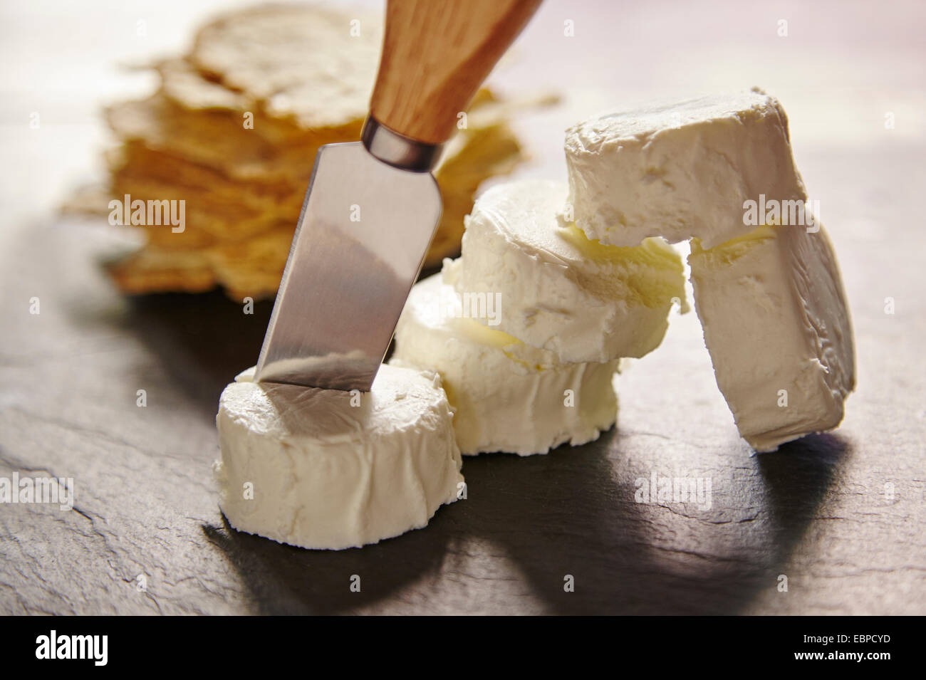 Organic French farmers goat cheese cut with a knife on a cheese board