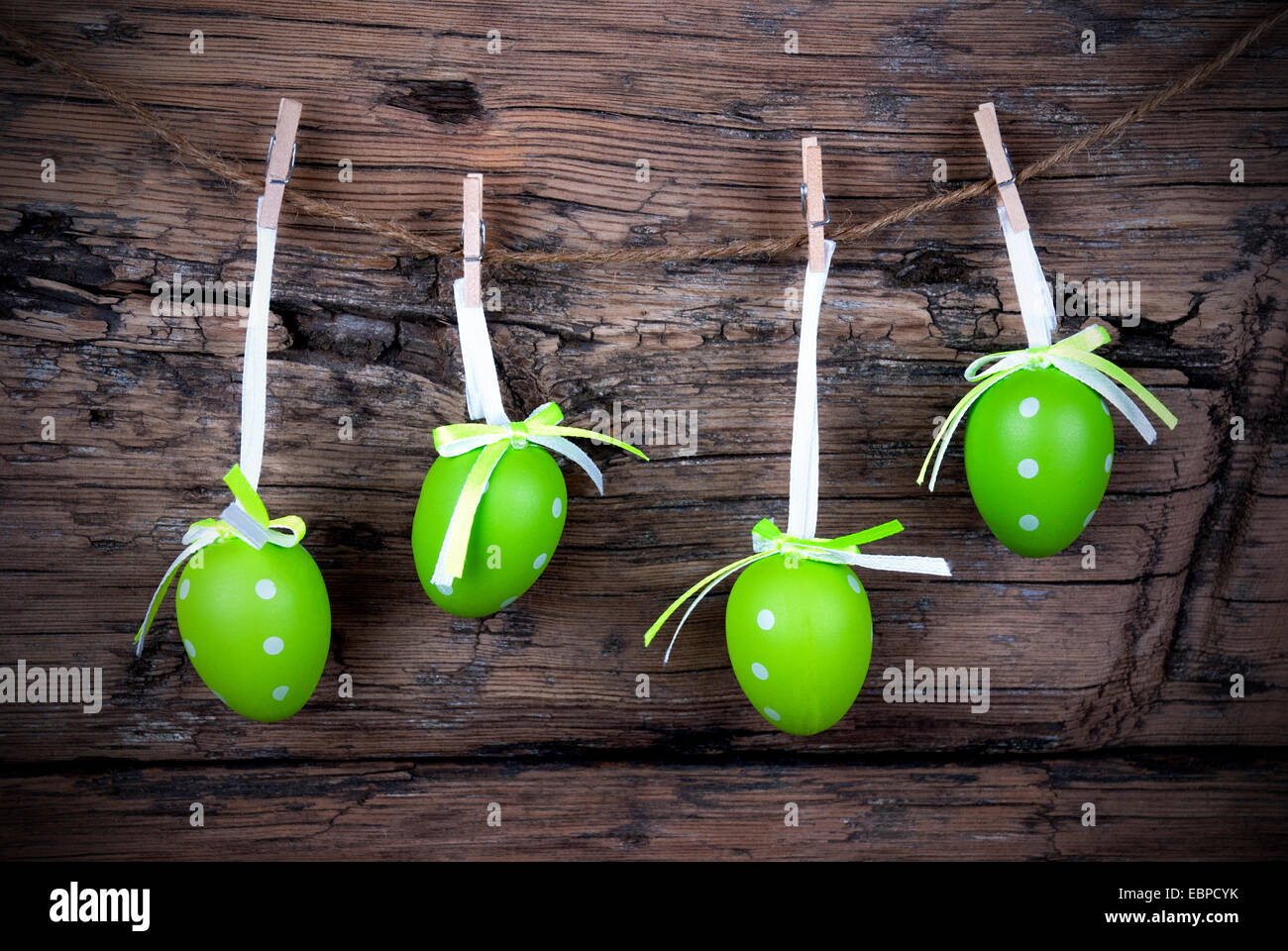 Four Green Easter Eggs Hanging On A Line On Wooden Background, Vintage
