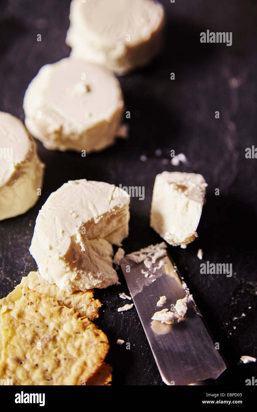 Organic French farmers goat cheese cut with a knife on a cheese board