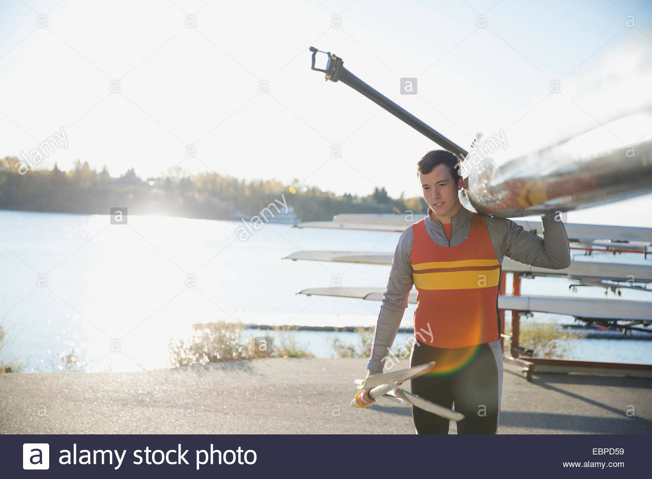 Rower carrying scull at waterfront Stock Photo