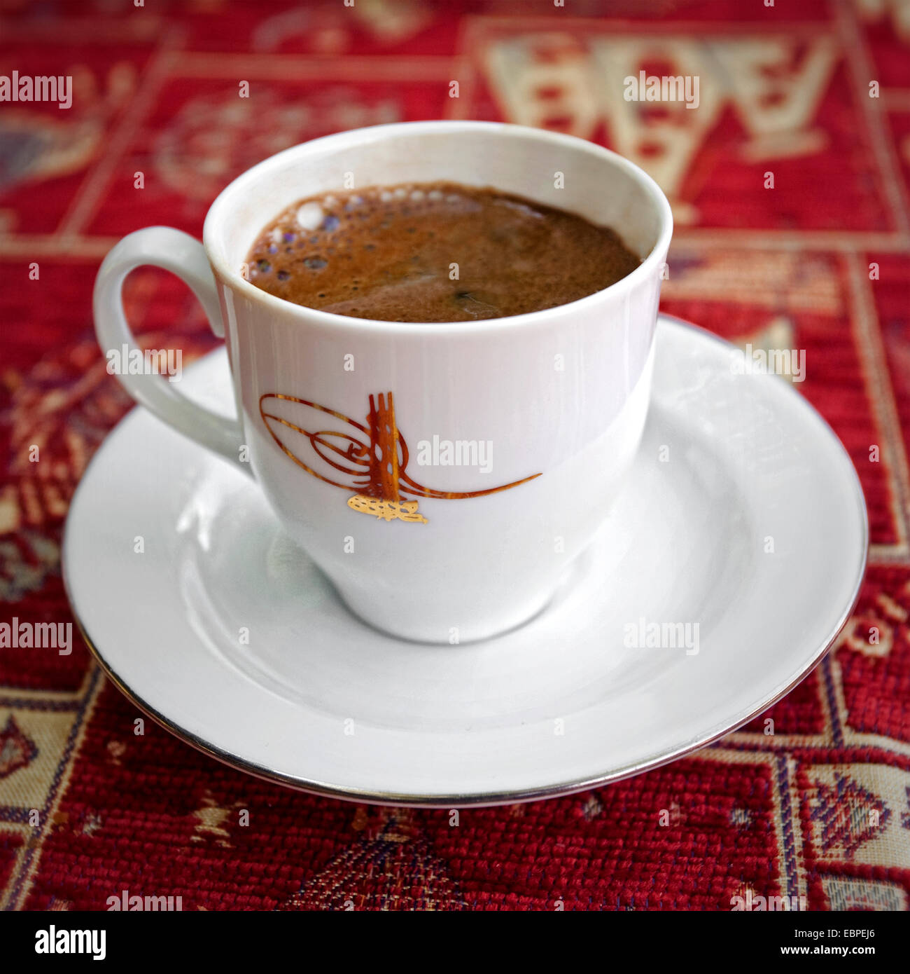 Close up of cup of turkish coffee sitting on red table clothe Stock Photo