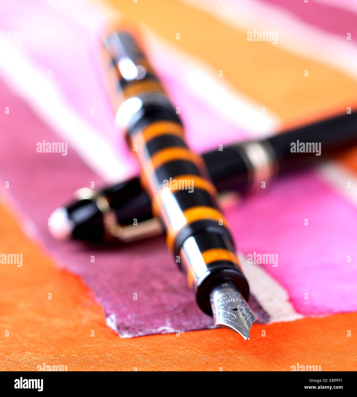 black and orange fountain pen pink orange silver tip Stock Photo
