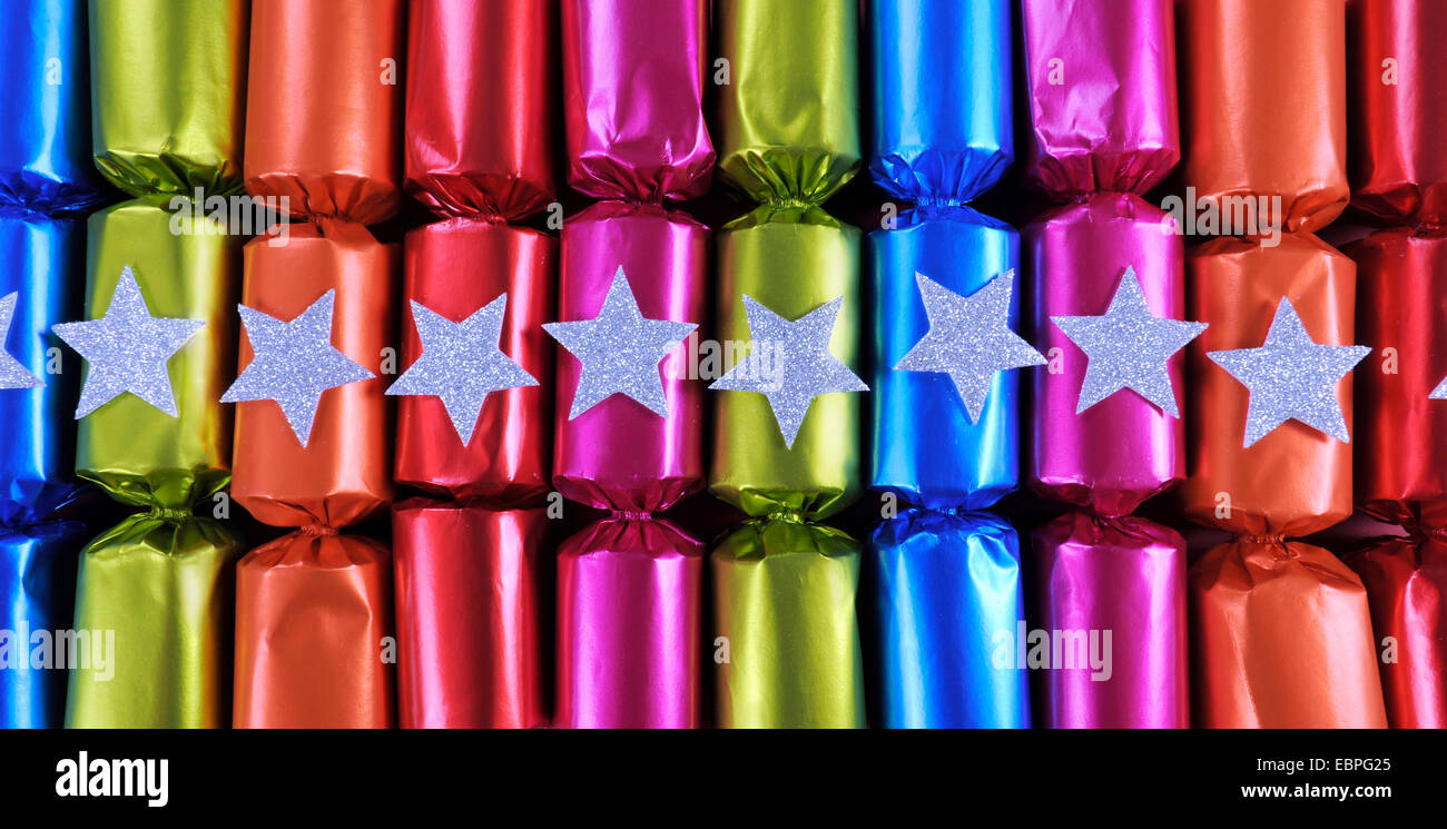 Row of shiny festive Christmas cracker bon bons in bright cheerful red, pink, orange, blue and
