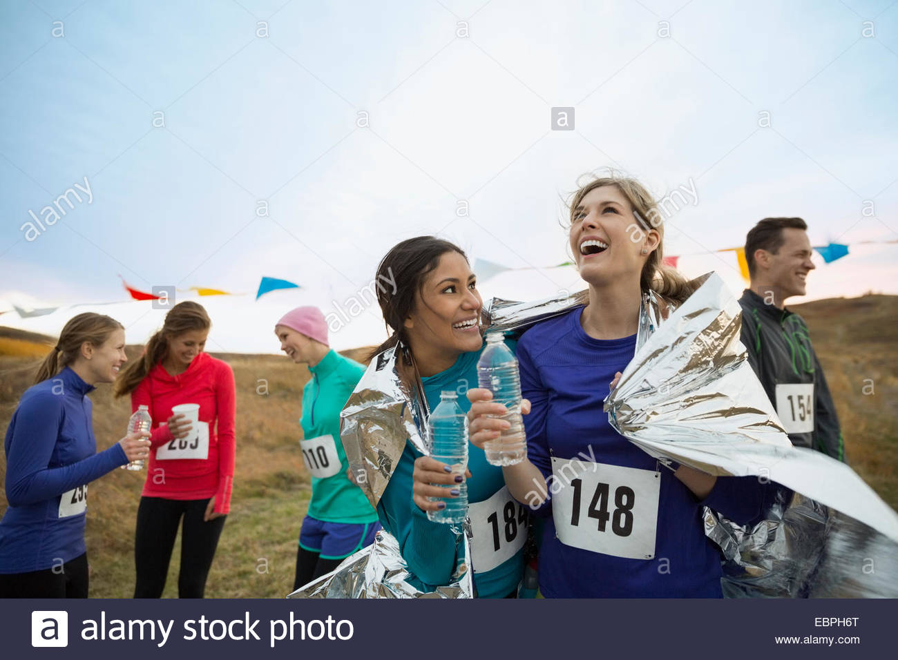 Smiling runners drinking water after marathon Stock Photo Alamy