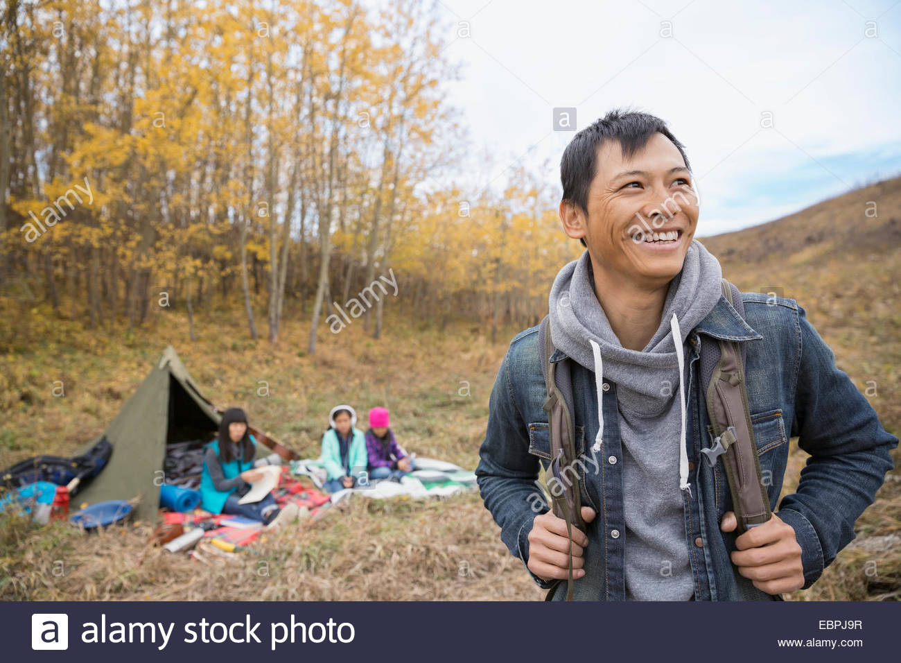 Smiling man camping with family Stock Photo