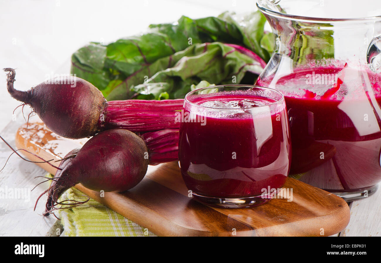Beetroot  juice and bunch of fresh beetroots with leaves. Selective focus Stock Photo