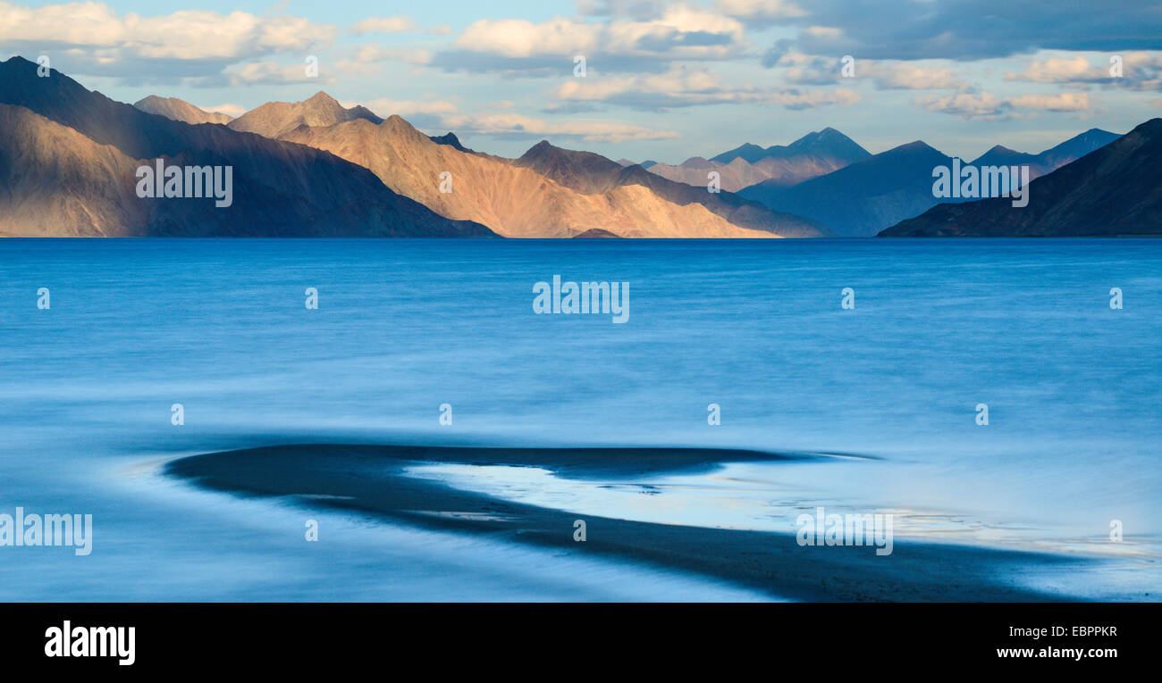 The turquoise, saline water of Tso Pangong, backed by mountains in the evening sun, Ladakh, India, Asia Stock Photo