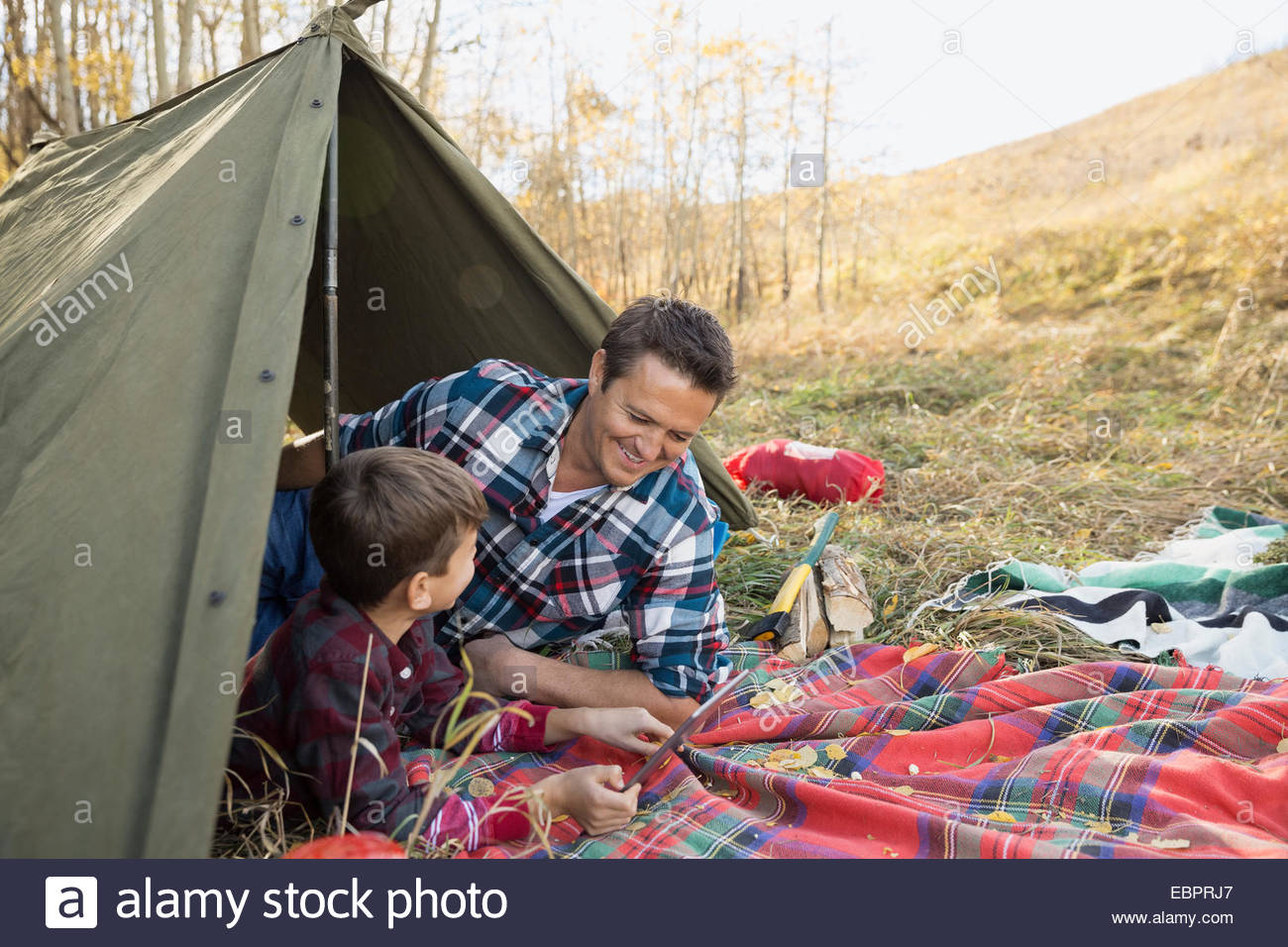 Father and son using digital tablet in tent Stock Photo