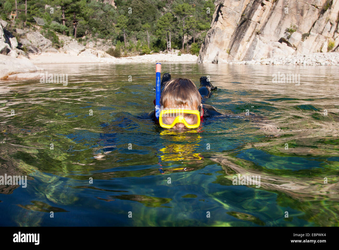 boy snorkeling in a crystal clear stream, France, Corsica Stock Photo