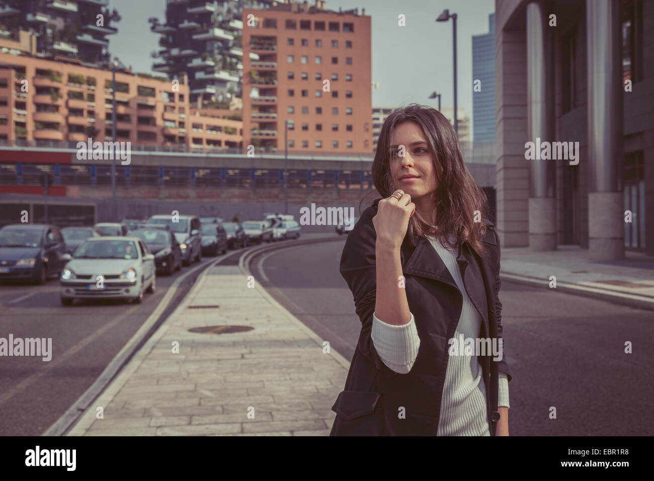Pretty girl with long hair poses in the city streets Stock Photo - Alamy