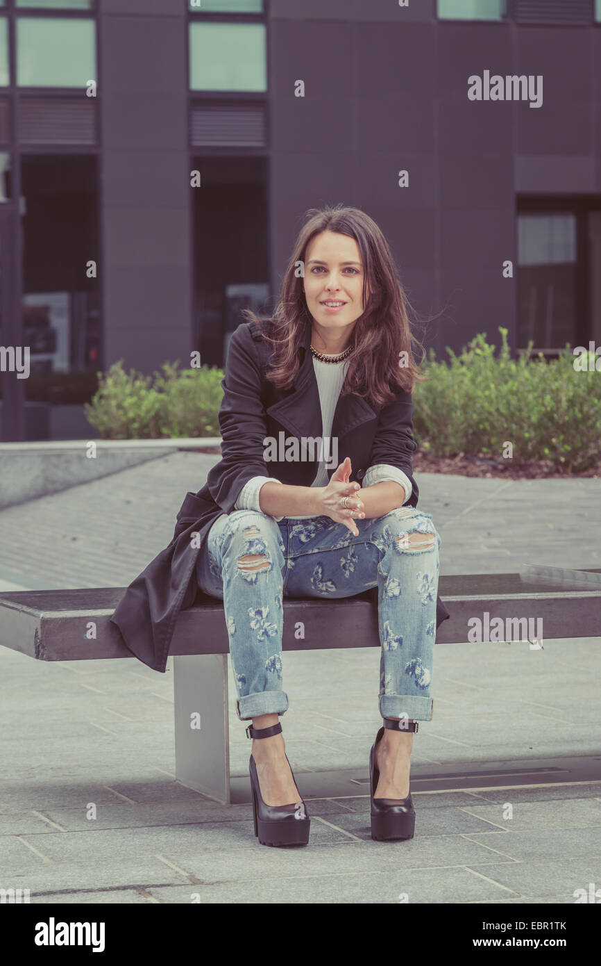 Pretty girl with long hair poses in the city streets Stock Photo - Alamy
