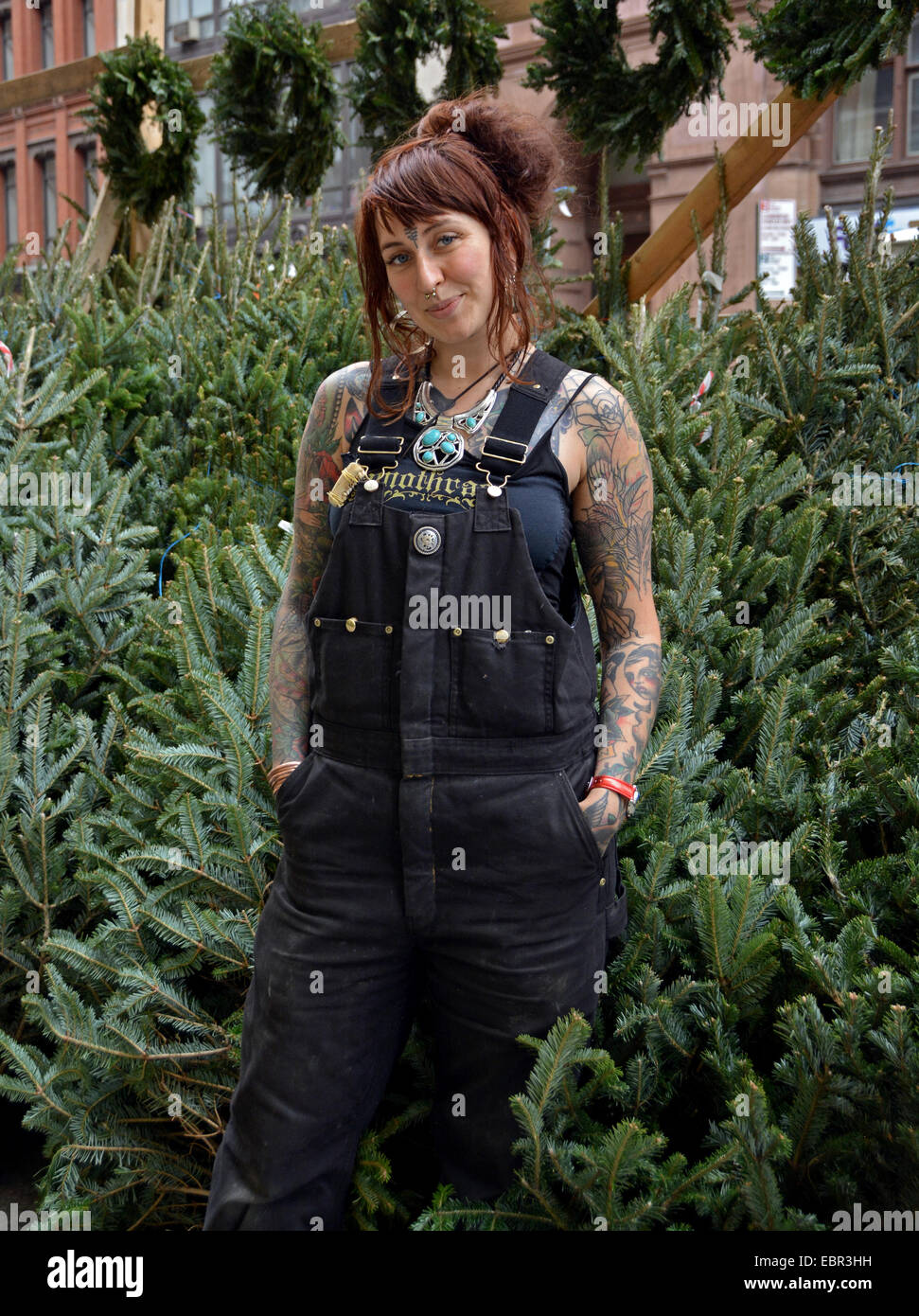 Portrait of a pretty young lady with tattoos from Scotland  selling Christmas trees in Greenwich Village, New York City Stock Photo
