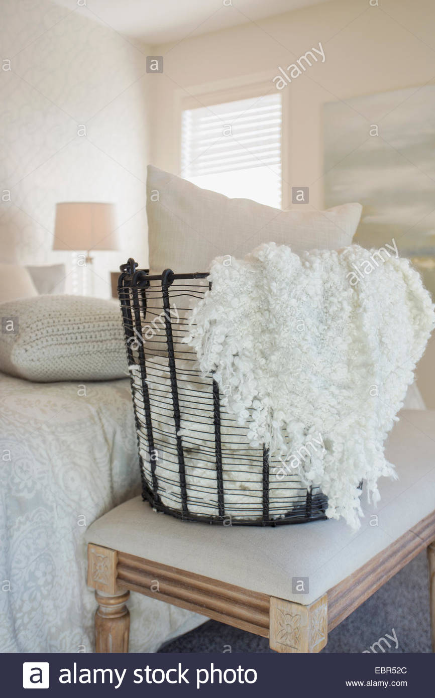 Pillow and blanket in wire bedroom basket Stock Photo Alamy