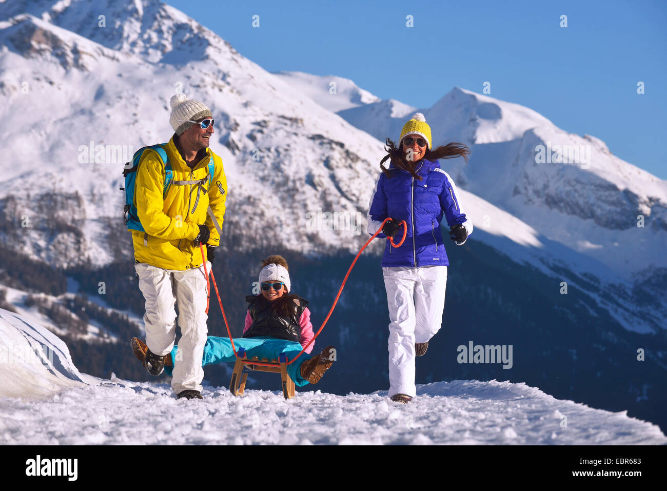 mother and father pulling their daughter on the toboggan, France Stock Photo