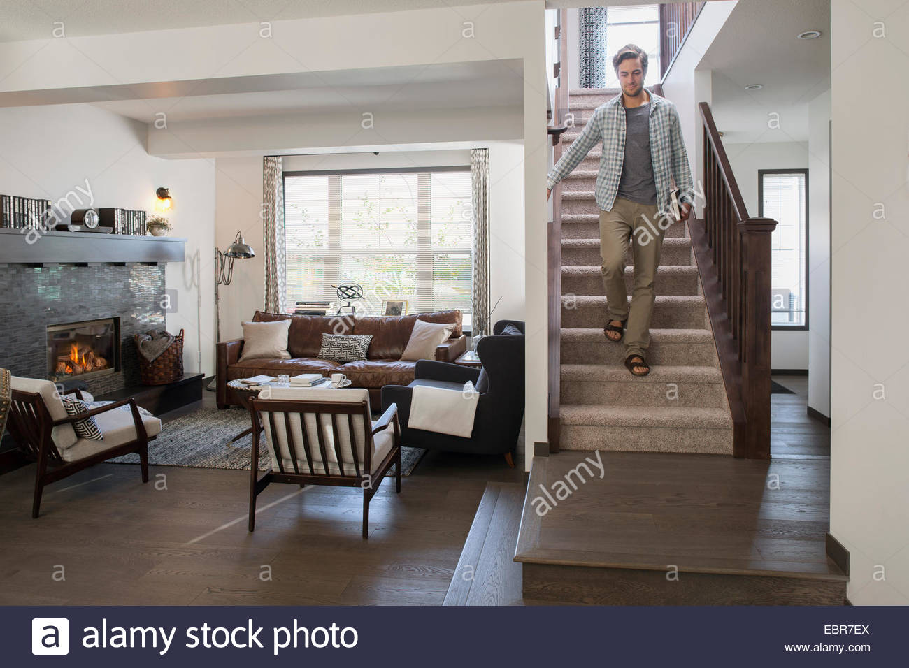 Man descending staircase in house Stock Photo
