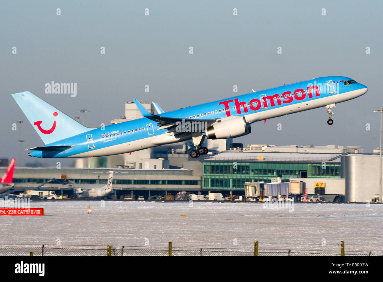 Thomson Airways Boeing 757-200 climbs away from a snow covered runway 05L at Manchester airport. Stock Photo