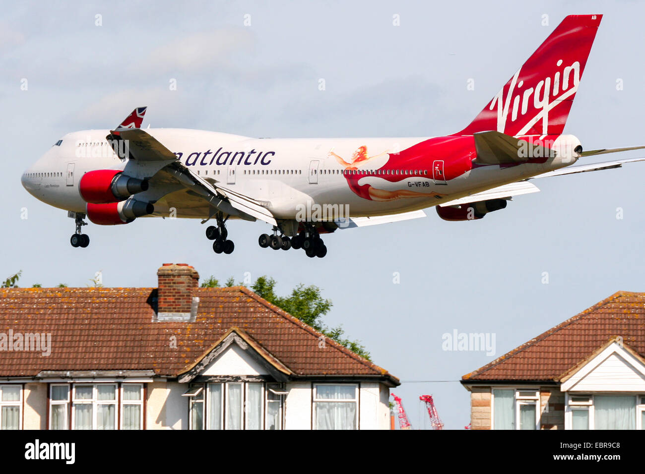 Virgin Atlantic Boeing 747-400 passes over nearby houses on approach to runway 27L at London Heathrow airport. Stock Photo