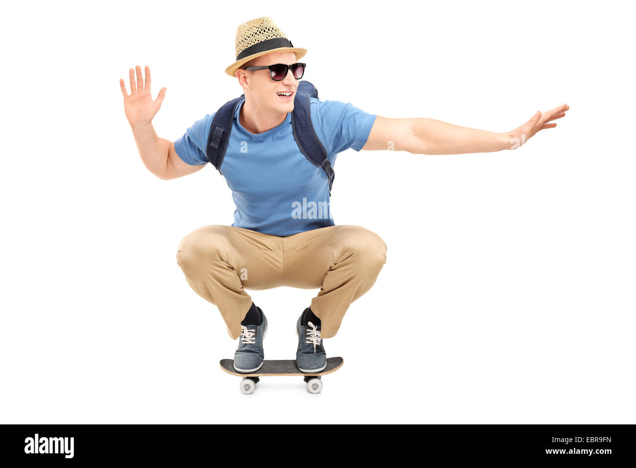 Cool young man riding a small skateboard isolated on white background Stock Photo