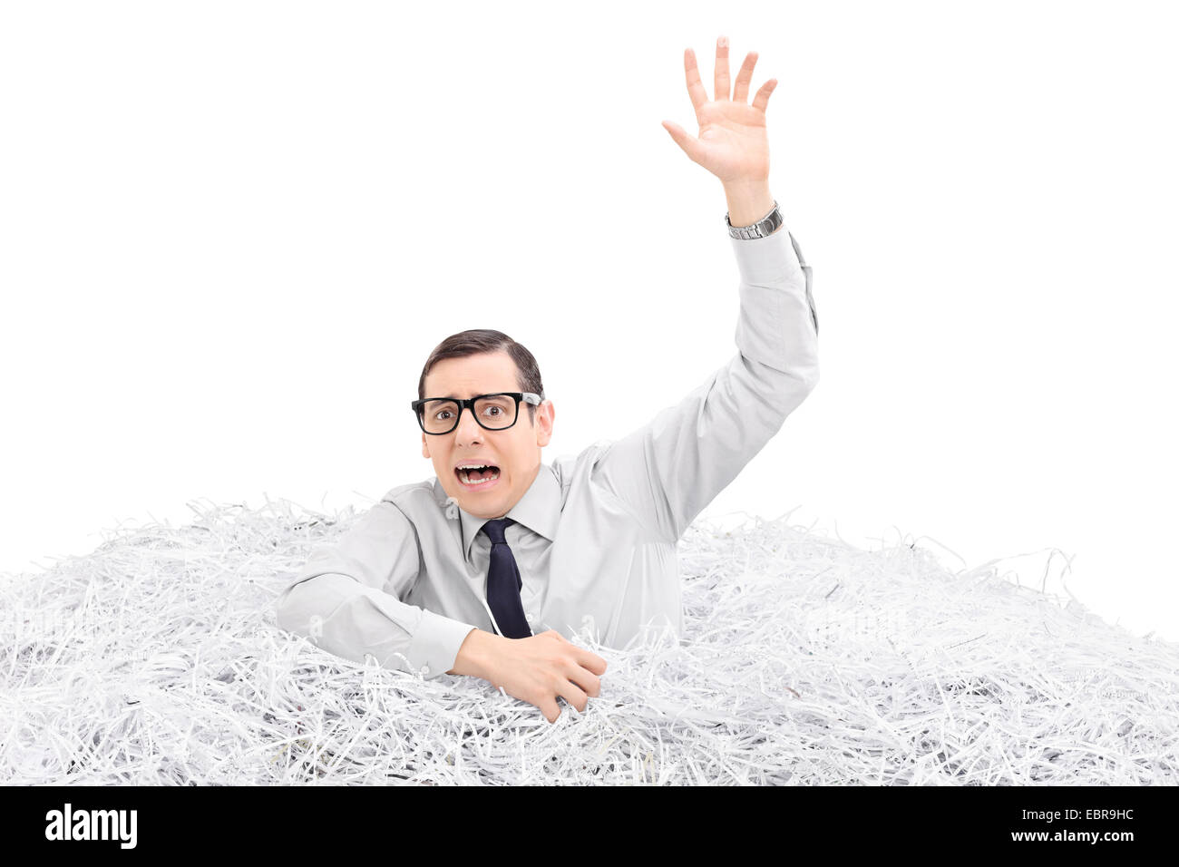 Helpless man drowning in a pile of shredded paper isolated on white background Stock Photo