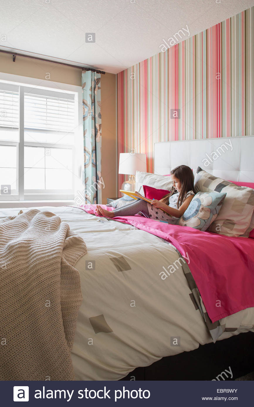 Girl writing on bed Stock Photo