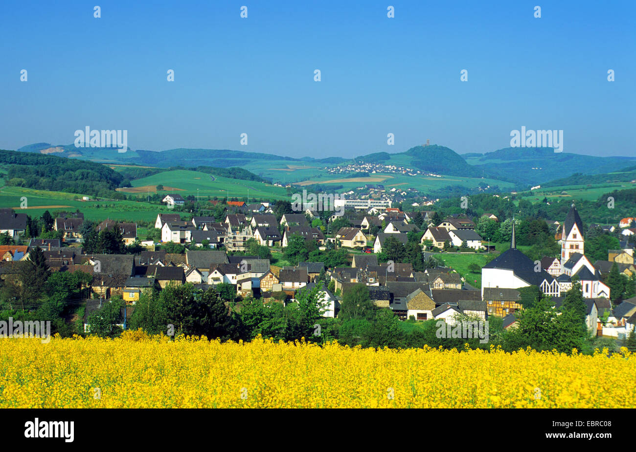 view to Niederzissen and Old Brueck ruin, blooming rape field in foreground, Germany, Rhineland-Palatinate, Eifel Stock Photo