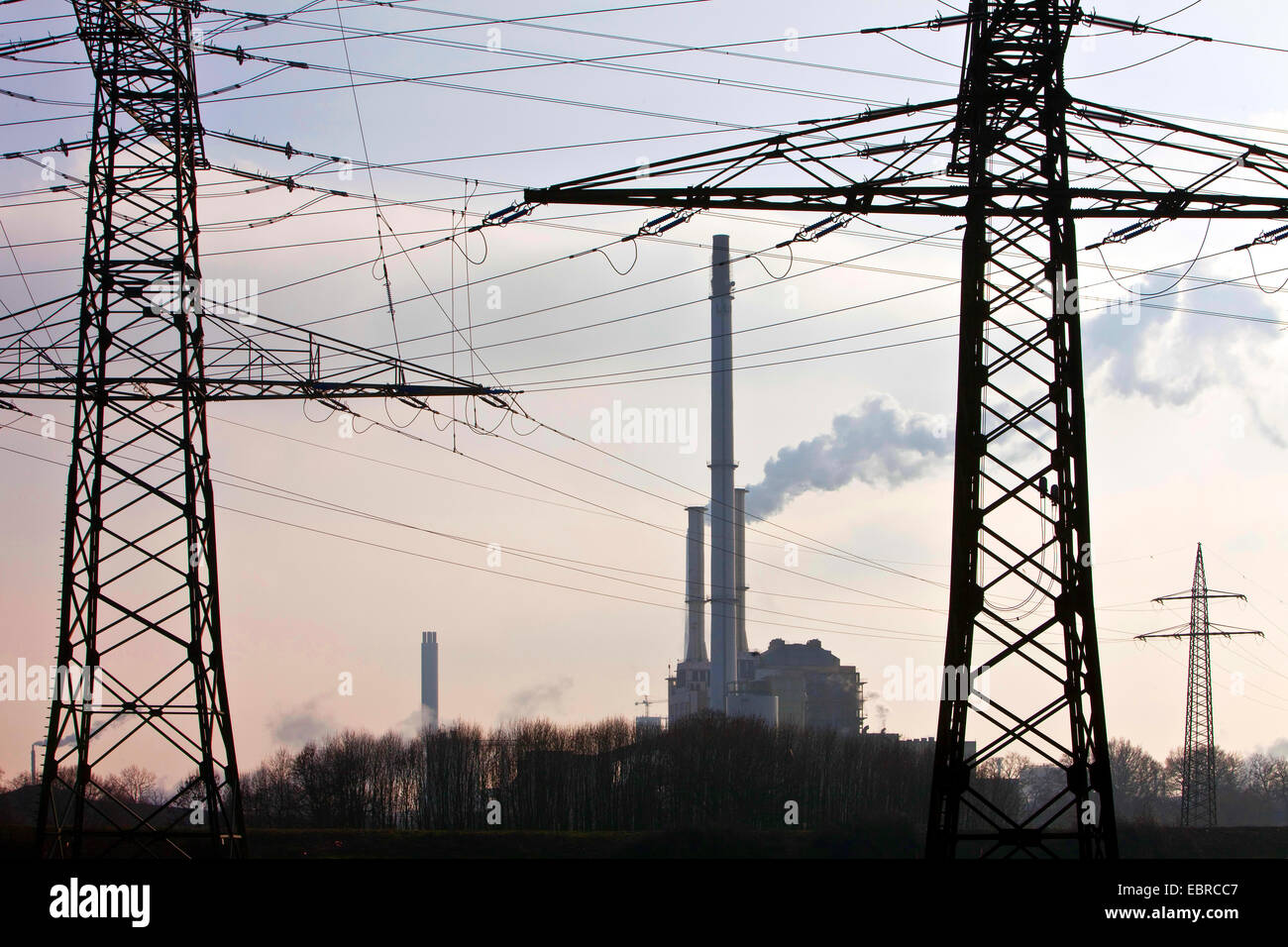 power poles with high voltage power lines and industry, Germany, North Rhine-Westphalia Stock Photo