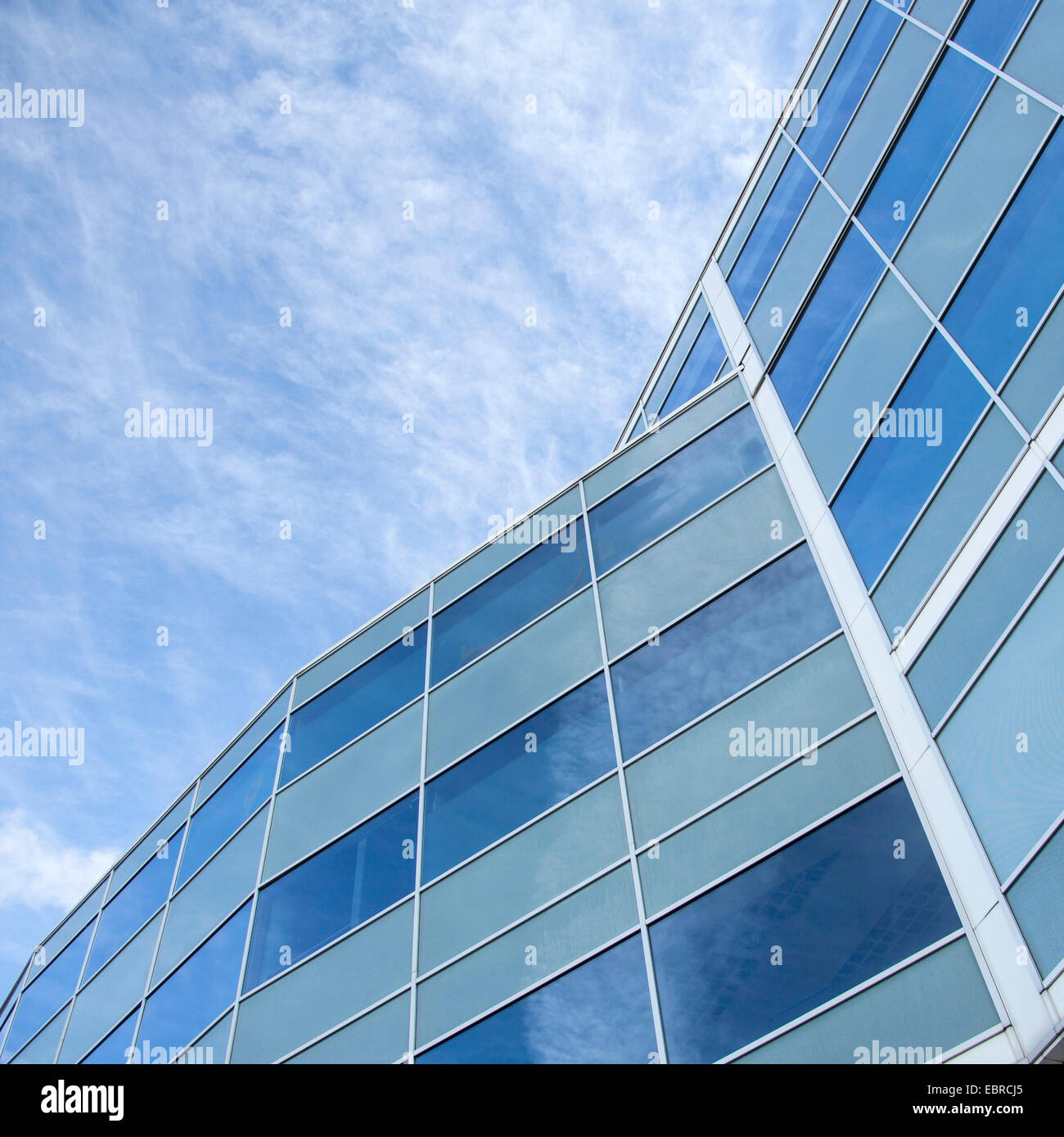 facade of glass and steel with reflections of blue sky and clouds Stock Photo