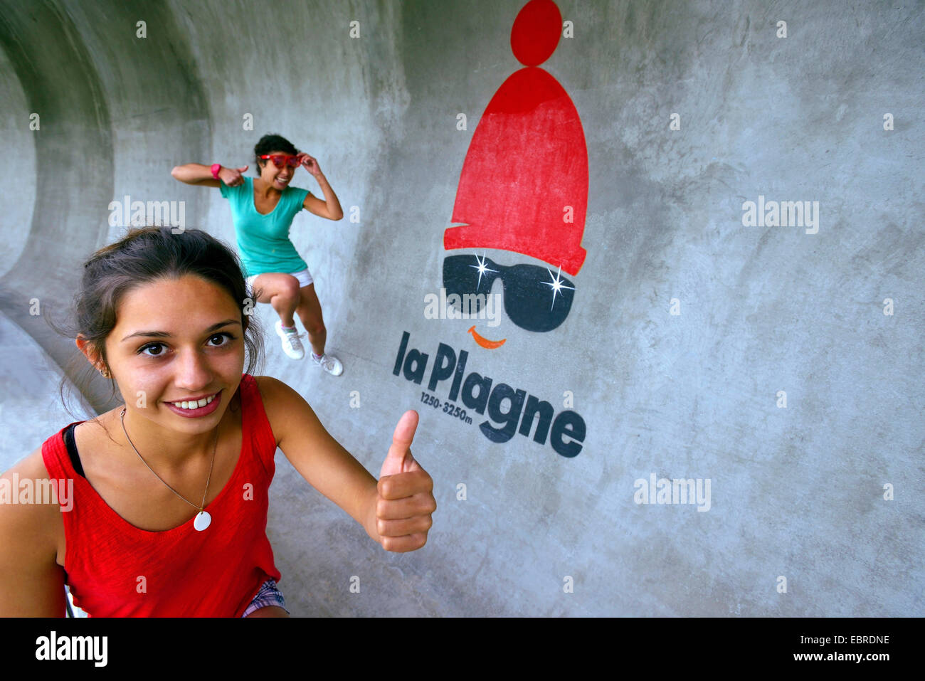two young women running on the bobsleigh track in summer, France, Savoie, La Plagne Stock Photo