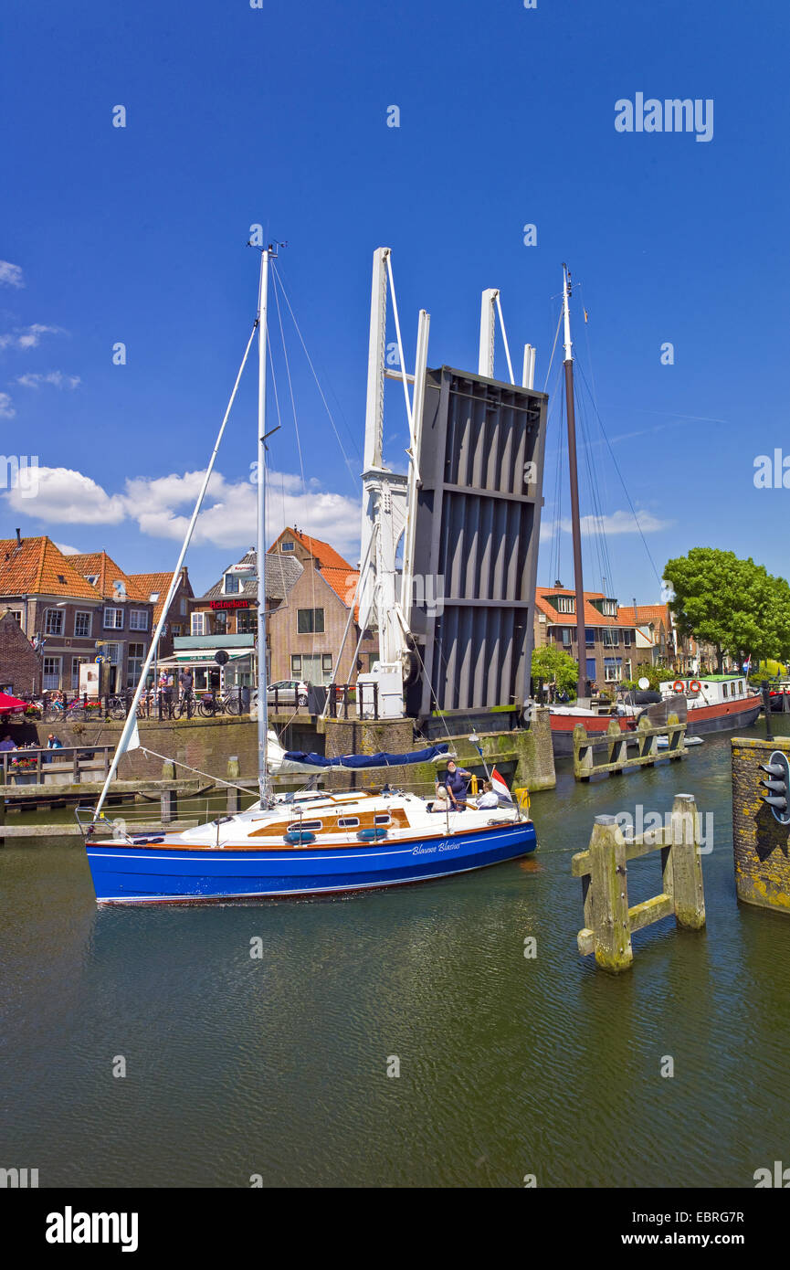 sailing boat leafing the port Oude Haven and crossing an open bascule bridge, Noord Holland, Netherlands, Enkhuizen Stock Photo