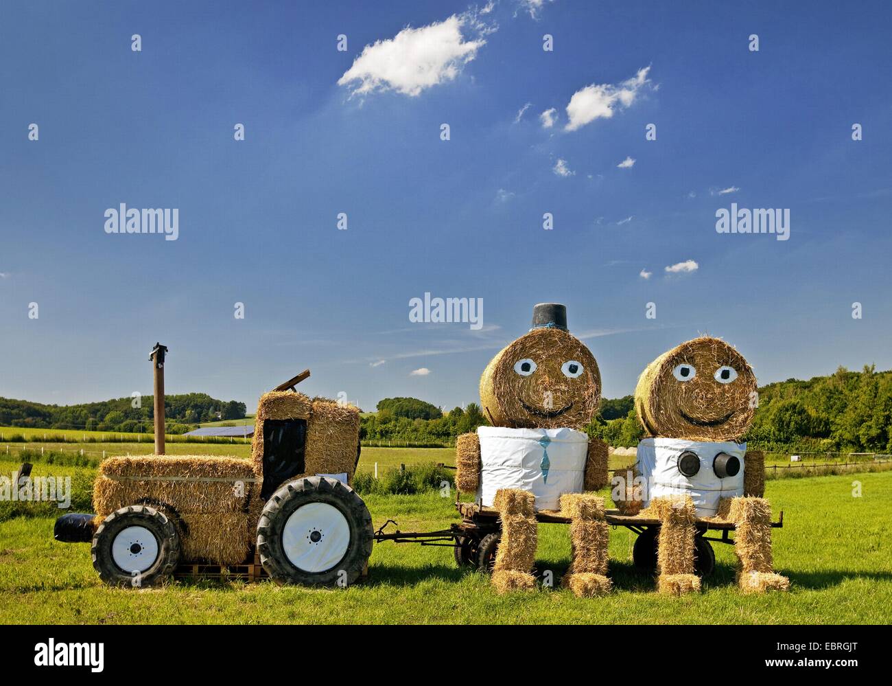 tractor and a couple made of bales of straw, Germany, North Rhine-Westphalia, Coesfeld Stock Photo