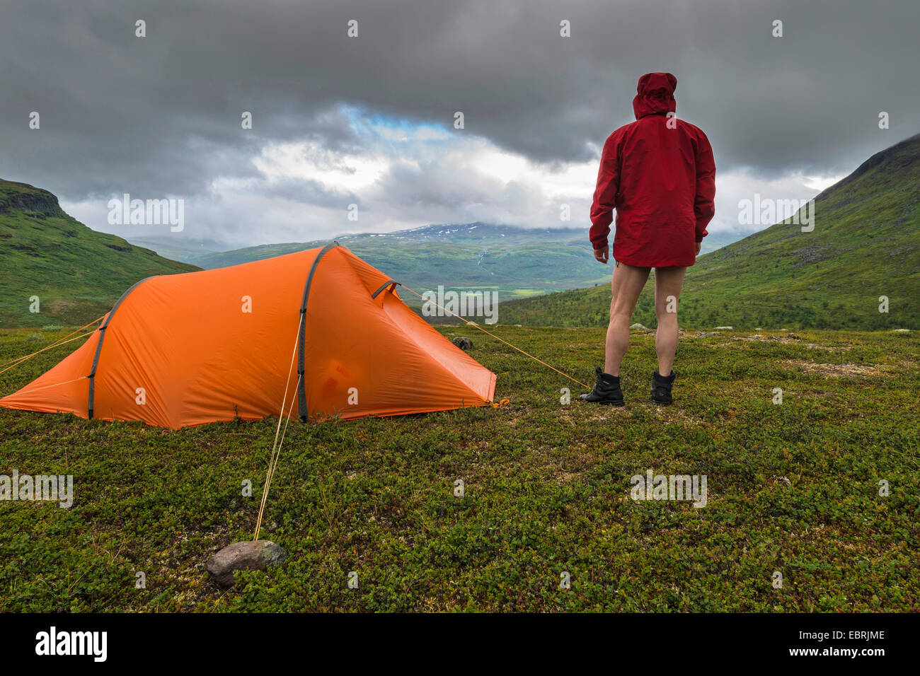 man next to his tent at the Ballinvaggi valley, Sweden, Lapland, Abiskoalpen Stock Photo