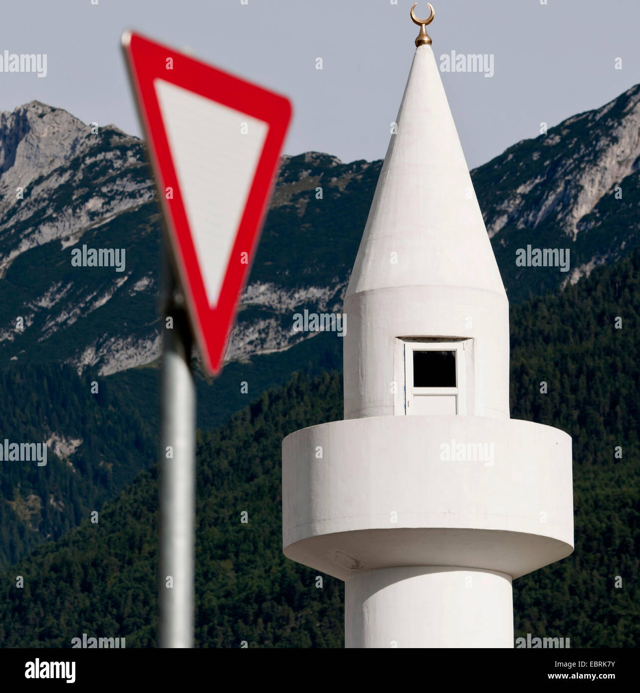 minaret and give way sign in front of looming mountains, Austria, Tyrol, Telfs Stock Photo