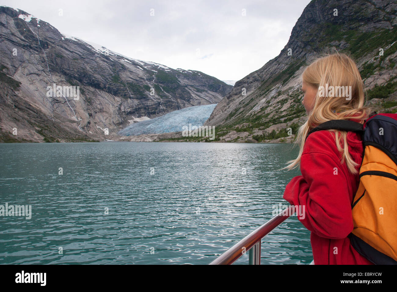 child on a ship on glacial lake Nigardsbrevatnet looking at glacier tongue Nigardsbreen, Norway, Jostedalsbreen National Park, Jostetal Stock Photo
